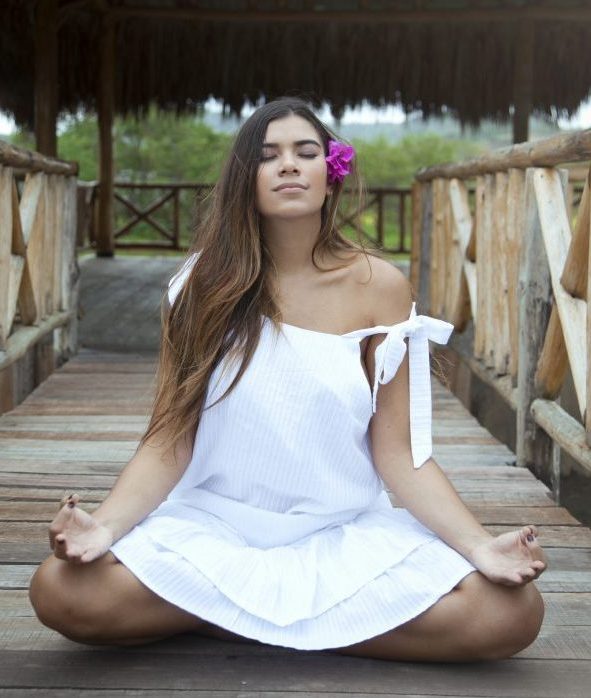 ¿Qué es una vida balanceada? ¿Cómo lograr llevar una vida balanceada? Mujer realizando meditación logrando una vida balanceada