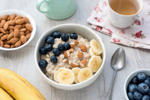 Desayuno nutritivo con bol de avena acompañado de frutos secos y arandanos Bol de frutas con frutos secos