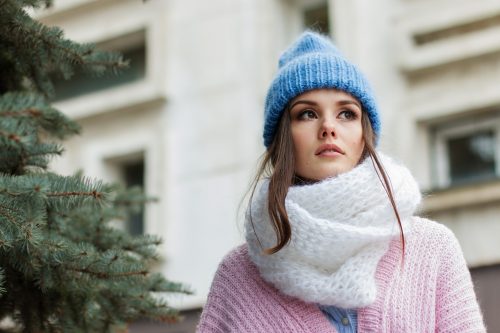 Cómo preparar tu cuerpo en el invierno para cuidar tu salud y sentirte más feliz Mujer pensativa con ropa de invierno para cuidar su salud