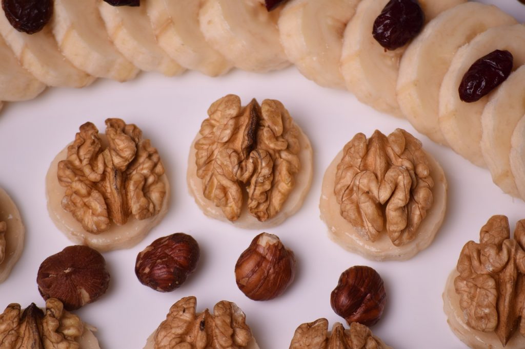 plato decorado con plátanos, nueces y almendras naturales Frutos secos, un alimento ideal para las personas diabéticas