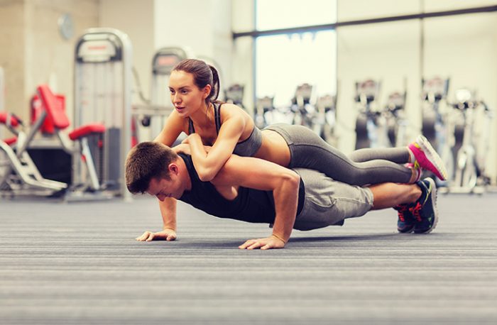 hombre realizando lagartijas y pareja sobre el para tonificar brazos