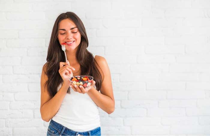 Una chica comiendo comida sana para un estilo de vida saludable