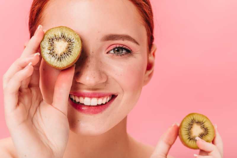 Kiwi: Aprende todos los beneficios que tiene esta fruta beneficios del kiwi- Mujer con kiwi