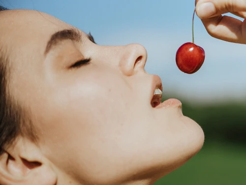mujer comiendo cereza, Alimentos que reducen el estrés