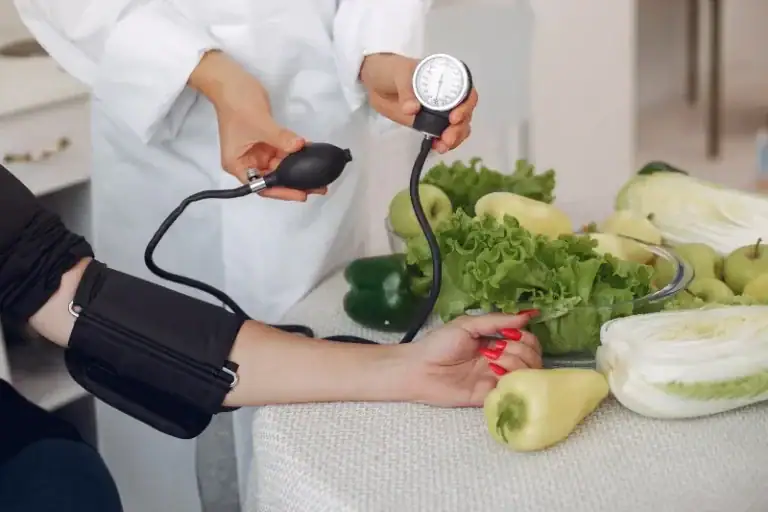 A woman is measuring the blood pressure of a person